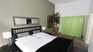 a bedroom with a bed with a mirror and a green cabinet at Loft Wernigerode Erdgeschoss in Wernigerode
