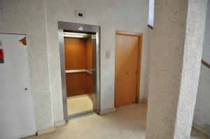 un corridoio vuoto con una porta in un edificio di RNET - Joncar Mar Roses a Roses