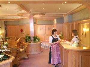 奧博沃爾法赫的住宿－莎切爾加尼咖啡廳酒店，两名妇女站在旅馆房间的柜台上