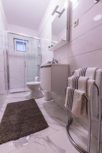 bagno bianco con lavandino e servizi igienici di Apartments D&A a Zara (Zadar)
