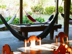 2 Hängematten und ein Billardtisch auf der Terrasse in der Unterkunft El Peregrino in Moyogalpa