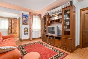 a living room with a couch and a tv at Apartment Noa Opatija in Opatija