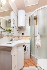 uma casa de banho com um lavatório e uma máquina de lavar roupa em Apartment Noa Opatija em Opatija