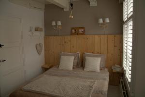 a bedroom with a bed with a wooden wall at De Slapende Leeuw in Middelburg
