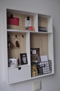 un estante de libros con libros y otros artículos. en De Slapende Leeuw, en Middelburg