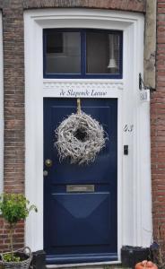 een blauwe deur met een krans erop bij De Slapende Leeuw in Middelburg