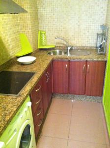 a kitchen with wooden cabinets and a sink and a dishwasher at Sun and Beach Spain 1B in Nerja