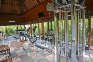 einen Fitnessraum mit Laufbändern und Maschinen in einem Zimmer mit Fenstern in der Unterkunft Grand Mega Resort & Spa in Cepu