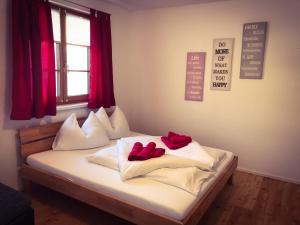 a bedroom with a bed with red pillows on it at Bergblick in Grossarl