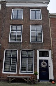 una casa de ladrillo con una puerta y ventanas azules en De Slapende Leeuw, en Middelburg