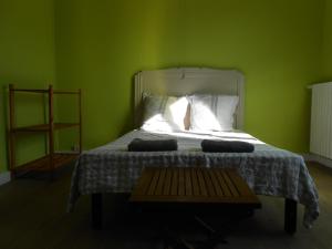 um quarto com uma cama com uma parede verde em L Hote Saison em Conflans-sur-Seine