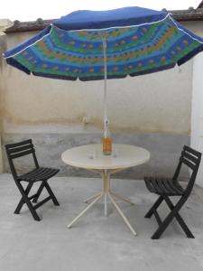 une table et deux chaises sous un parasol dans l'établissement L Hote Saison, à Conflans-sur-Seine