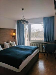 a bedroom with a large bed and a window at Hotel Peter Schaefer in Ginsheim-Gustavsburg