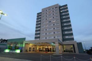 a large white building with a street in front of it at Porto Feliz Executive Hotel in Pôrto Feliz