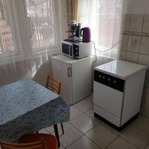ハイドゥソボスローにあるMuskátli Apartmanの小さなキッチン(テーブル、電子レンジ付)