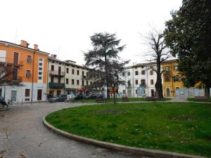 a city street with buildings and a park with grass at Residenza Meeting in Verona