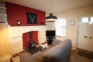 - un salon avec un canapé et une cheminée dans l'établissement Cosy Crickhowell Cottage, à Crickhowell