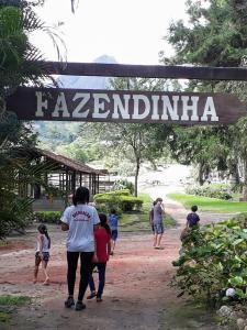 Un groupe de personnes marchant sous un panneau indiquant fazendailli dans l'établissement Hotel Fazenda São Moritz, à Teresópolis