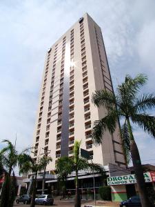 wysoki budynek z palmami przed nim w obiekcie Bristol Evidence Hotel w mieście Goiânia