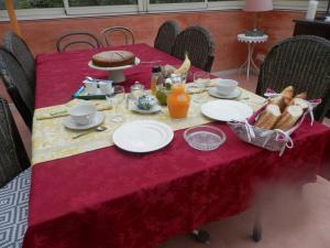 a table with a red table cloth with food on it at La Guerandelle in Ernes