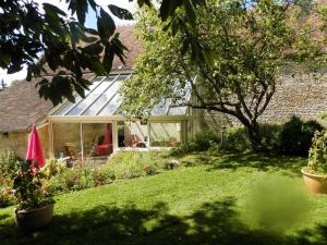 a house with a conservatory in a yard at La Guerandelle in Ernes