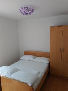 a bedroom with a bed and a wooden cabinet at Apartments Vido in Vodice