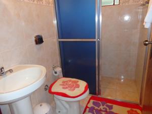 a bathroom with a shower with a toilet and a sink at Recanto Monte Verde in Monte Verde