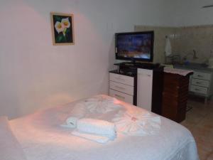 a bedroom with a bed with towels on it at Recanto Monte Verde in Monte Verde