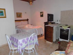 a bedroom with a bed and a table and chairs at Recanto Monte Verde in Monte Verde