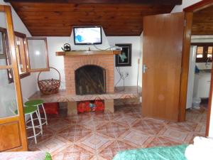 a living room with a fireplace with a tv on top at Recanto Monte Verde in Monte Verde