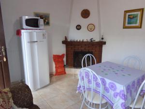 a dining room with a table and a fireplace at Recanto Monte Verde in Monte Verde