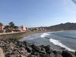 a beach with a bunch of rocks and the ocean at Appartamento Erika in Gran Tarajal