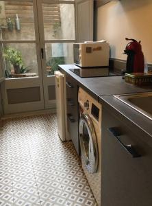 a kitchen with a washing machine on a counter at Allotjament Barri Vell Girona in Girona