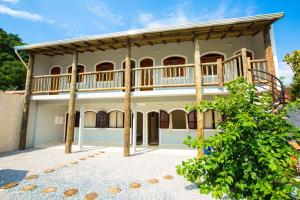 an exterior view of a house with a balcony at Pousada da Árvore in Boicucanga