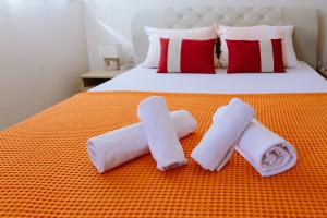 a bed with two towels and two rolled towels at Sun City Apartments in Trebinje