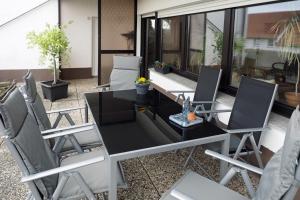 a patio with a black table and chairs at Ferienwohnung Rosenpflanzer in Bad Oeynhausen