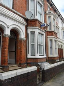 a red brick house with a door and windows at Comfort Guest House in Leicester