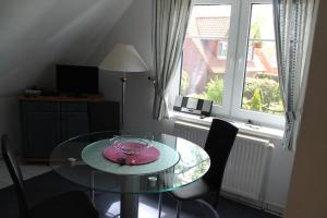 a glass table and chairs in a room with a window at Am Ostseestrand in Zingst