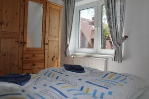 a bedroom with a bed with a window and blue sheets at Am Ostseestrand in Zingst