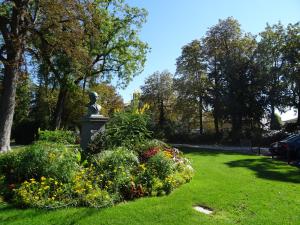 una estatua en un parque con flores en la hierba en Face Au Jardin, en Cognac