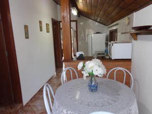 a table with a vase of flowers on top of it at Recanto Monte Verde in Monte Verde