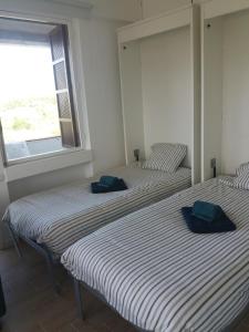 two twin beds in a room with a window at Apartamento Alvor in Alvor