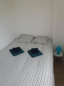 Una cama con dos toallas azules encima. en Apartamento Alvor en Alvor