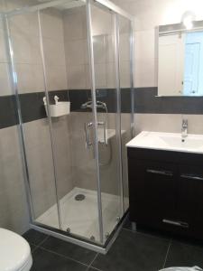 y baño con ducha, aseo y lavamanos. en Apartamento Alvor, en Alvor