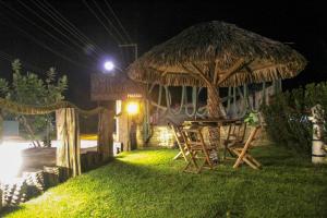 een restaurant met een tafel en een rieten parasol bij Solar das Gaivotas Pousada in Barreirinhas
