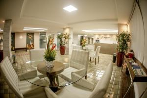 een lobby met een tafel en witte stoelen bij Petrolina Palace Hotel in Petrolina