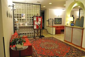 un vestíbulo de tienda con un sofá rojo y una alfombra en Al Fogher, en Treviso
