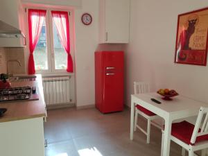 Il comprend une cuisine équipée d'un réfrigérateur rouge et d'une table. dans l'établissement AREA 14 NAVIGLI HOME, à Milan