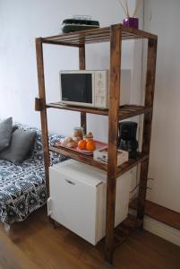 a room with a shelf with a microwave and a bed at Casa Miraya in Almería