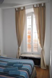 a bedroom with a bed and a window with curtains at Casa Miraya in Almería